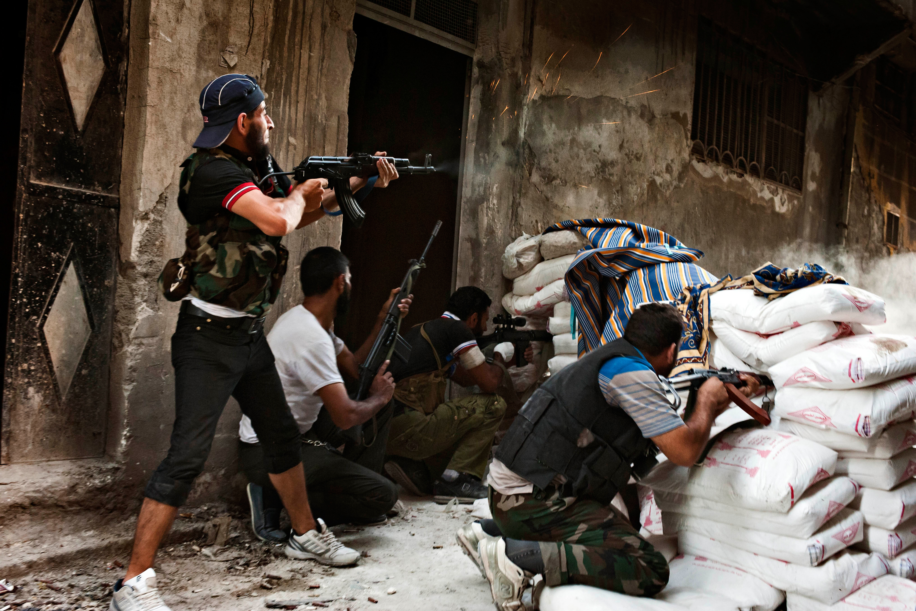 Free Syrian Army fighters exchange fire with regime forces in the Salah Al Din neighborhood of Aleppo, Aug. 22.
